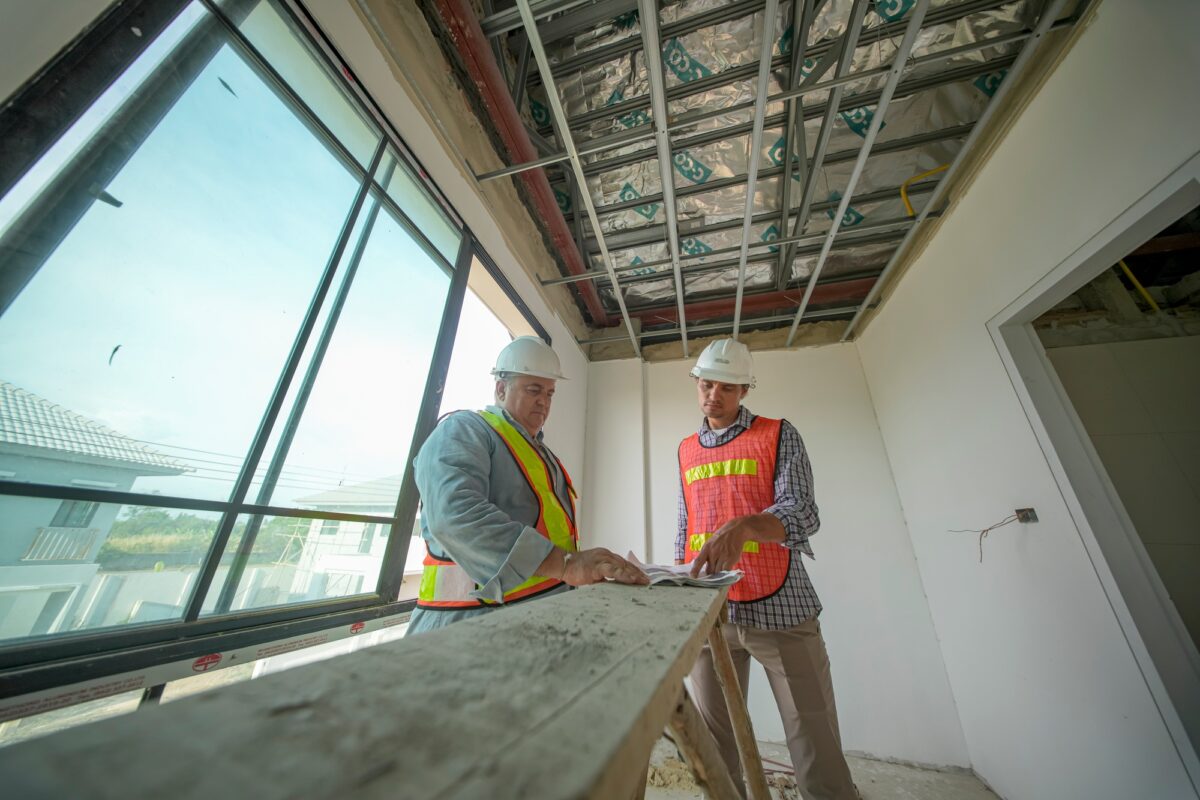 Construction workers collaborate on a project inside a new building during the day