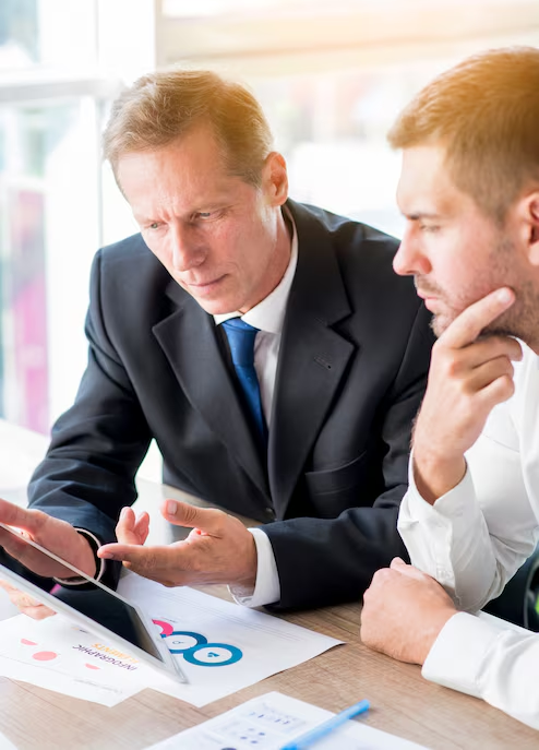 Businessmen reviewing digital data on a tablet, discussing company reputation management.
